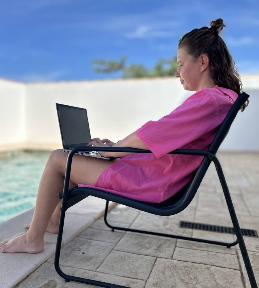 Dorota Anna trabajando con el portátil junto a la piscina